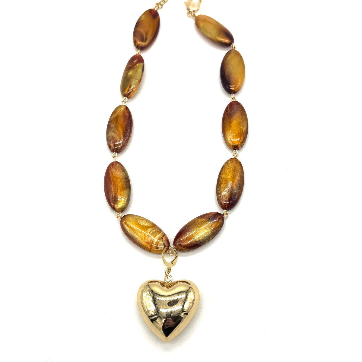 Necklace with brown oval beads and a gold heart pendant on a white background