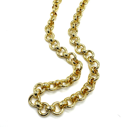 A close-up of a gold chain necklace with large, polished links, arranged in a loose curve on a plain white background.